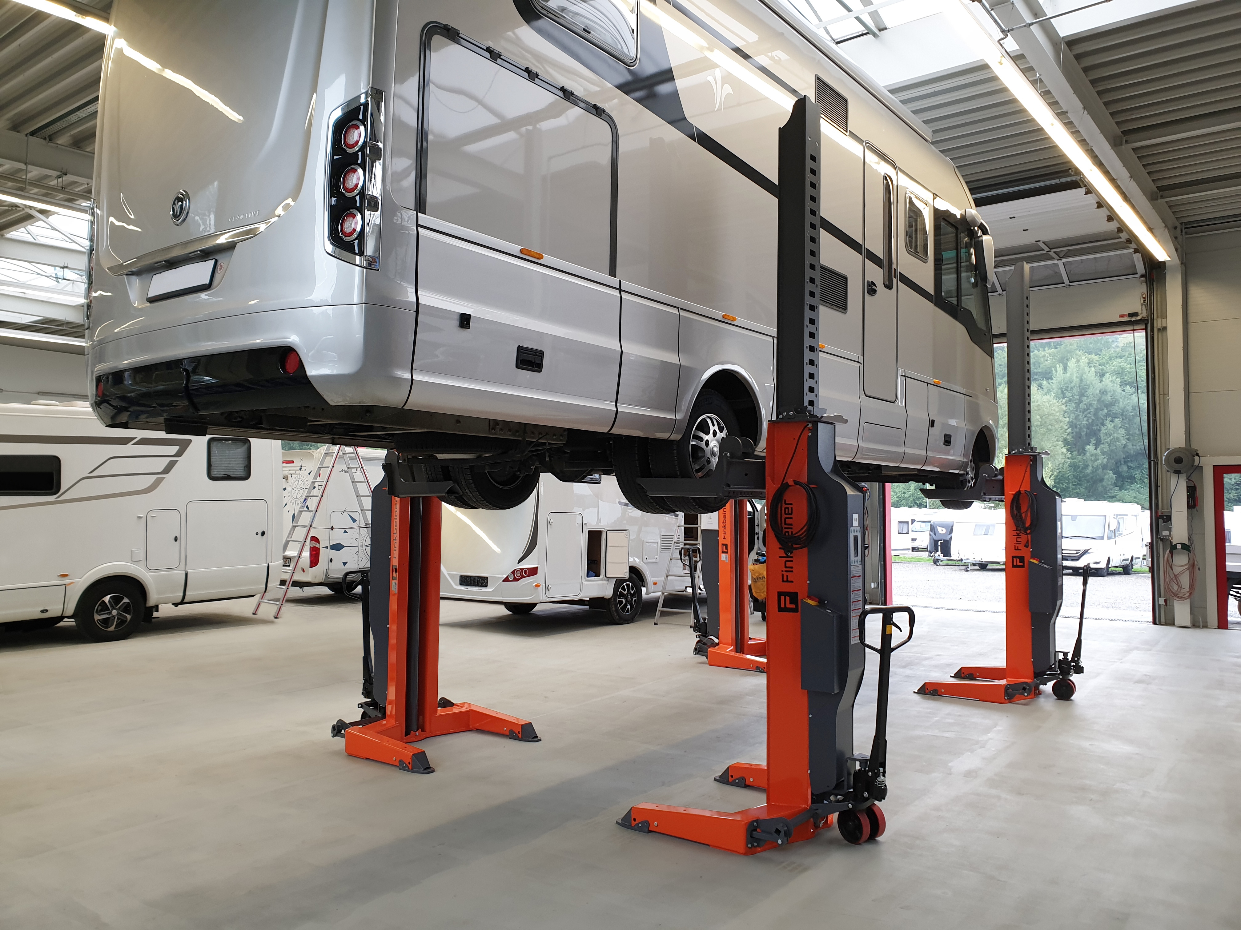 Using four mobile columns, a camper van is lifted for maintenance works in a workshop of a caravanning dealer.