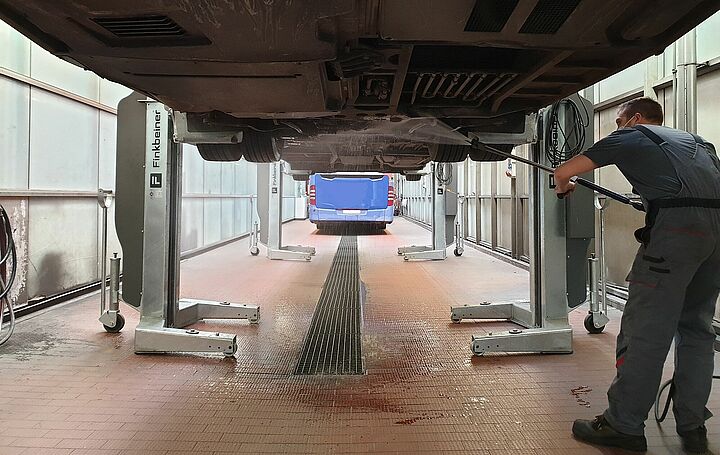 Pont élévateur avec un bus soulevé dans une salle de lavage