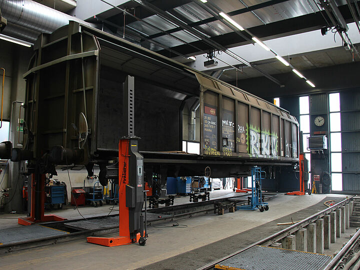 Angehobener Waggon bei SBB Cargo mithilfe von akkubetriebenen Hebeböcken