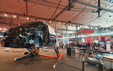 VW ID van lifted by a mobile two-post lift at an exhibition in Hanover